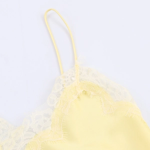 Detail of light yellow silk satin camisole with delicate lace trim and thin straps