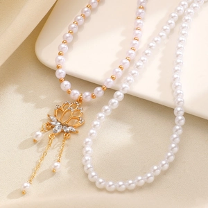 Exquisite pearl beaded necklace detail shot featuring crystal lotus pendant and delicate tassels.