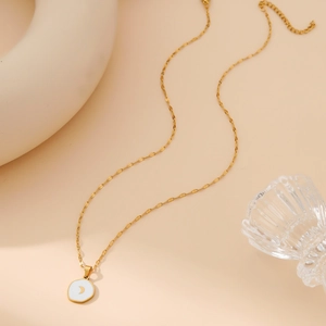 Elegant gold stainless steel moon pendant necklace on a white enamel round charm