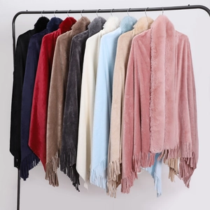 Detail view of winter double-sided flannel ponchos with faux rabbit fur collars and tassels