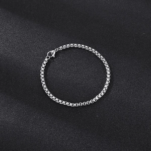 Close-up of a silver stainless steel box chain necklace with a classic lobster clasp