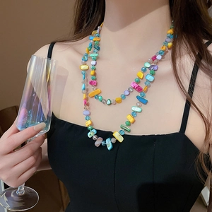 Gros plan d'un collier bohème à deux rangs avec des perles de verre colorées sur un mannequin