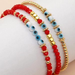 Gros plan de bracelets de perles Evil Eye rouges avec billes dorées et détails soignés