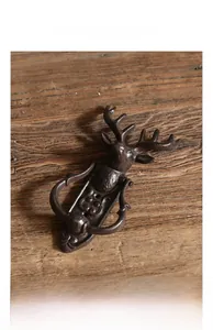 Détail d'un heurtoir de porte en fonte en forme de cerf avec texture rustique sur bois
