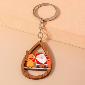 Gros plan du porte-clés en bois en forme de goutte avec Père Noël et renne peints