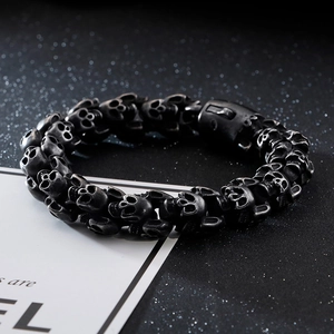 Macro view of heavy punk rock skull links with rustic silver finish on a steel bracelet