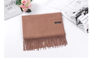 Detail of soft dark camel cashmere scarf with tassels and official material label