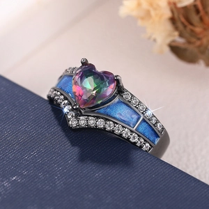 Vista macro de anillo corazón de topacio místico con baño negro y esmalte azul