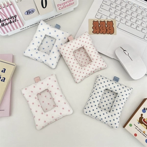 Close-up of cute plush star and polka dot card holders with PVC windows on a desk