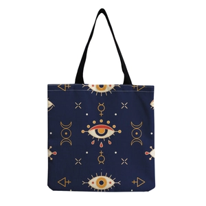 Detail of navy canvas tote bag with gold mystical eye and celestial moon phase pattern