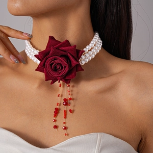 Vue détaillée du ras-de-cou à trois rangs de perles avec rose en velours et glands perlés