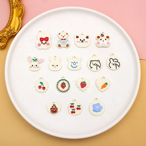 Detailed macro view of 15 various colorful alloy DIY charms with animal and fruit patterns