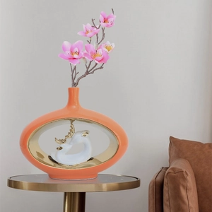 Vaso moderno in ceramica arancione con statuetta di cervo bianco e fiori di magnolia