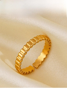 Vue macro d'une bague en acier inoxydable plaqué or 18 carats avec surface texturée sur soie
