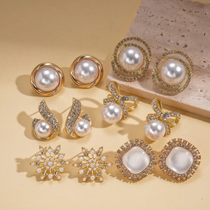 Detail of 6 pairs vintage gold earrings set with faux pearls and rhinestones on stone