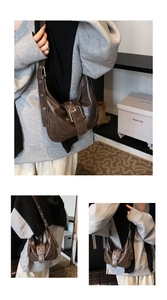 Detail view of dark brown leather crossbody bag with oversized metal buckle and wide strap