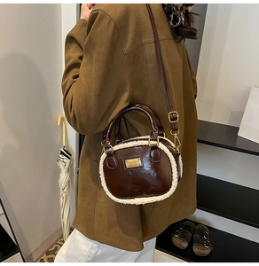 Detail of brown leather pillow bag featuring white faux shearling trim and gold plaque
