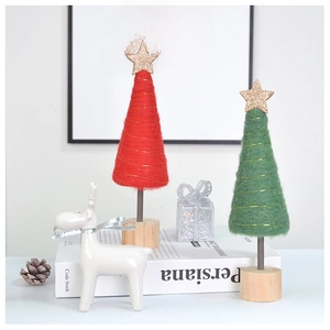 Detail of red and green wool felt Christmas trees with gold stars and wooden bases