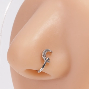 Macro détaillée d'un clip de nez argenté en U avec design lune et étoile en zircon