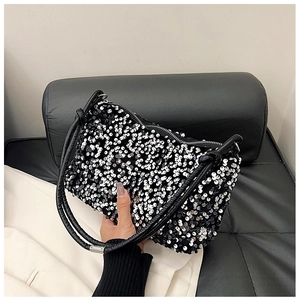 Detailed view of shimmering silver sequins on black crossbody bag with leather strap