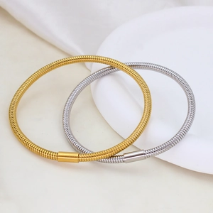 Detail of minimalist 18K gold and silver snake chain bracelet showing flexible texture