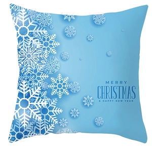Close-up of blue Christmas pillow cover with white snowflakes and festive greeting text
