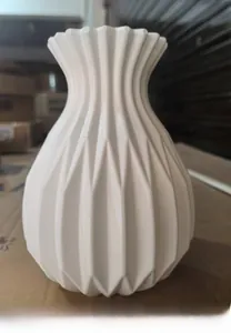 Close-up of geometric origami texture on a white minimalist plastic flower vase