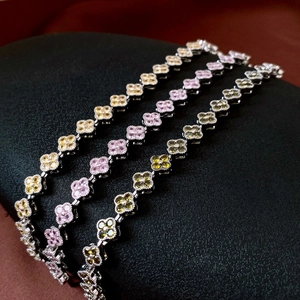Trois bracelets en argent avec zircons trèfles jaune, rose et vert sur support noir