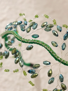 Dettaglio di cerchietto fatto a mano con cristalli blu e rifiniture in velluto verde