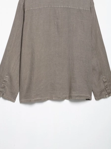 Detail view of linen blend shirt hem and buttoned cuffs in brownish-gray fabric texture
