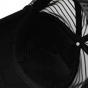 Detail view of the breathable mesh back and inner sweatband on a black trucker hat