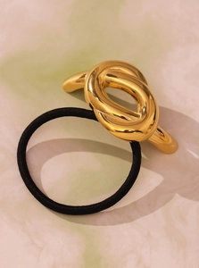 Detail view of a metallic gold knot hair tie with a black high-elasticity hair band