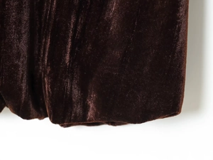 Vue macro de la texture du tissu en velours marron foncé avec des reflets doux et fibres