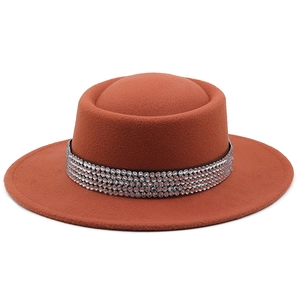 Dettaglio cappello in lana rosso ruggine con elegante fascia in strass di cristallo