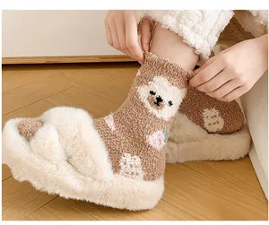 Close-up of thick coral fleece socks with cute brown bear patterns and pink accents