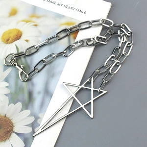 Close-up of punk style chain necklace with large hollow star pendant on decorative card