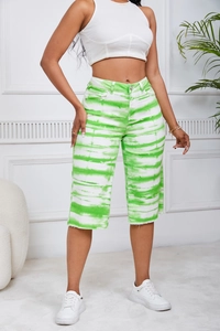 Detailed close-up of high-waist green tie-dye mid-length denim shorts on a model