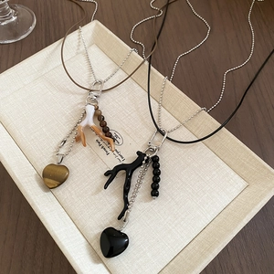 Detail of vintage heart pendant necklace with double-layer chain and coral branch charm