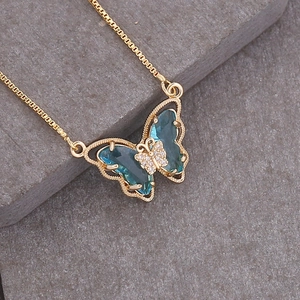Macro shot of gold necklace with a blue butterfly pendant and sparkling crystals