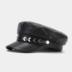 Dettaglio del cappello militare in pelle PU nera con borchie argentate e trama liscia