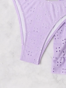 Close-up of lavender eyelet embroidery and ruffle detail on the bikini swimsuit