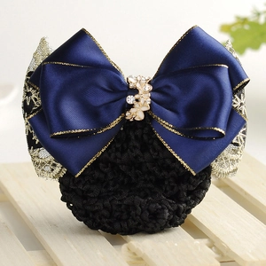 Détail d'un nœud en satin bleu marine avec résille noire et bordure en dentelle dorée