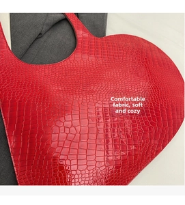 Detail of red heart-shaped tote bag showing crocodile texture and neat stitching