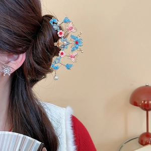 Détail d'un pic à cheveux vintage avec papillon en émail et perles sur le modèle