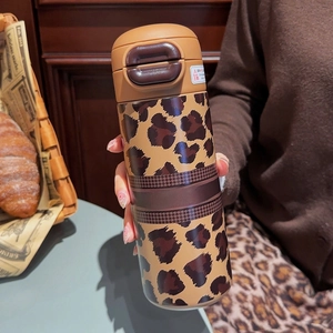 Detail of leopard print thermal mug with one-click lid and Glam Royal branding