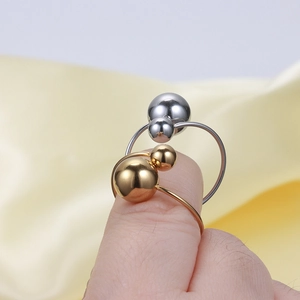 Polished gold and silver ball rings shown on fingers with a modern geometric design