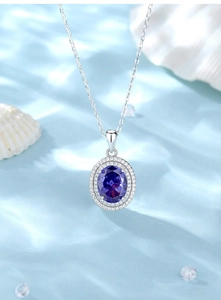 Macro shot of oval blue gemstone pendant with double-layer pavé diamonds on wavy background