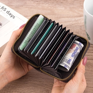 Detail of dark brown leather accordion wallet with 11 card slots and gold zipper
