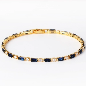 Detail eines Gold-Tennisarmbandes mit marineblauen Baguette-Steinen und weißen Diamanten