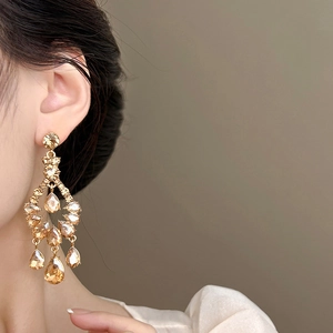 Gros plan de boucles d'oreilles pendantes dorées avec cristal ambre sur un mannequin